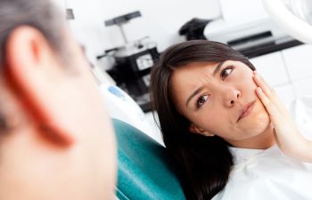 Woman suffering from dental pain at an emergecy dentist appointment